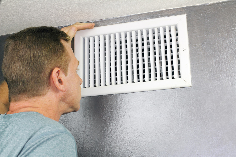 Man looking at an air duct