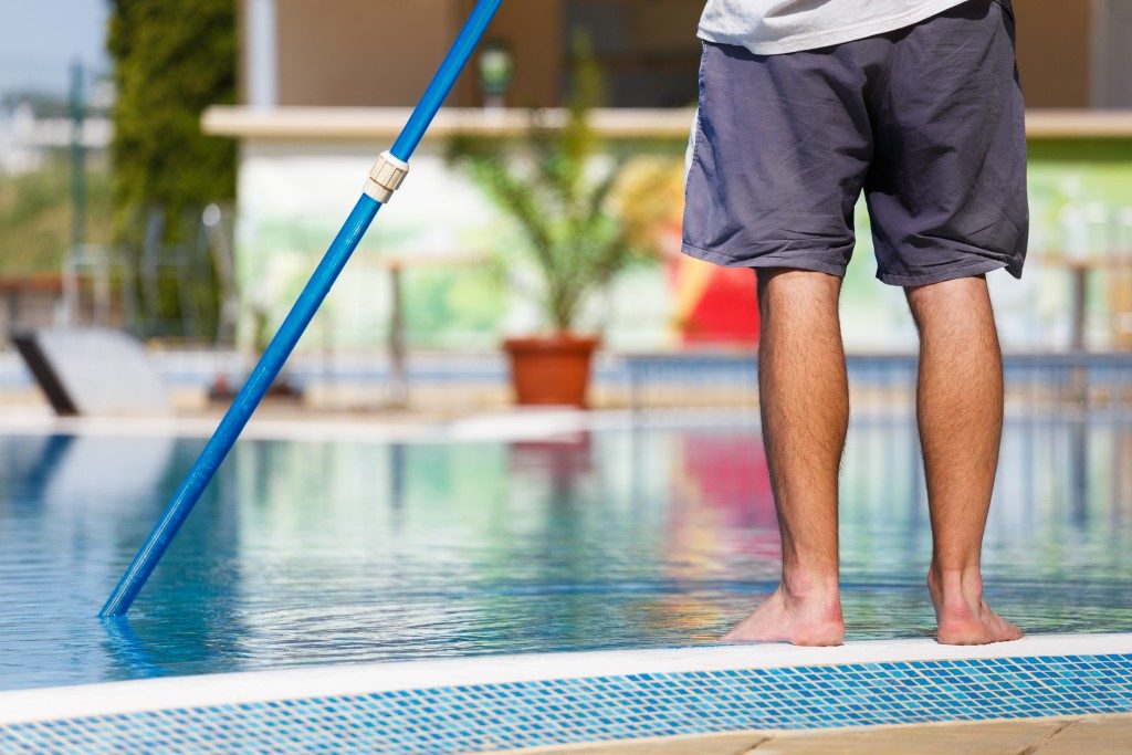 man cleaning the pool