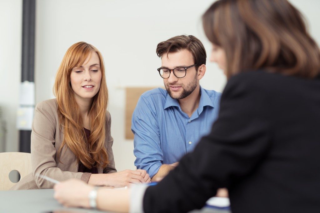 a couple talking to a real estate agent