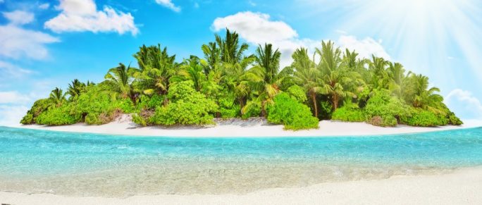 Whole tropical island within atoll in tropical ocean with timeshare text written on the sand