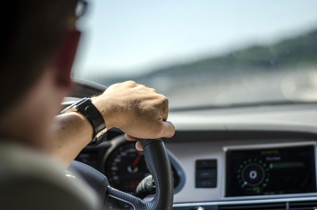 Man's Hand on Steering Wheel