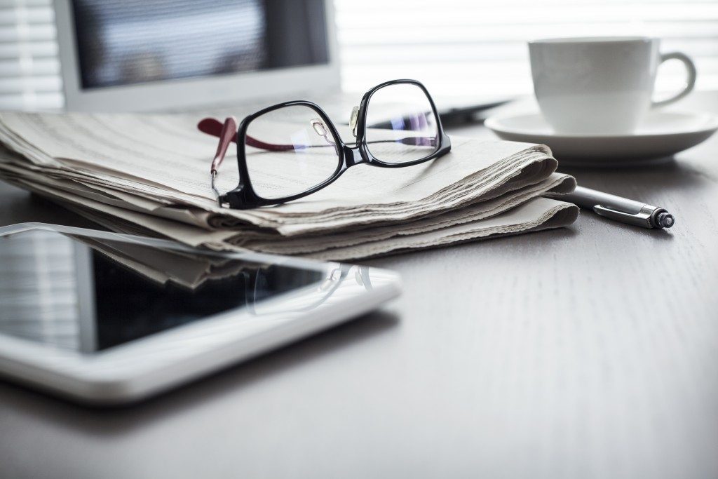 Newspaper and tablet on desk