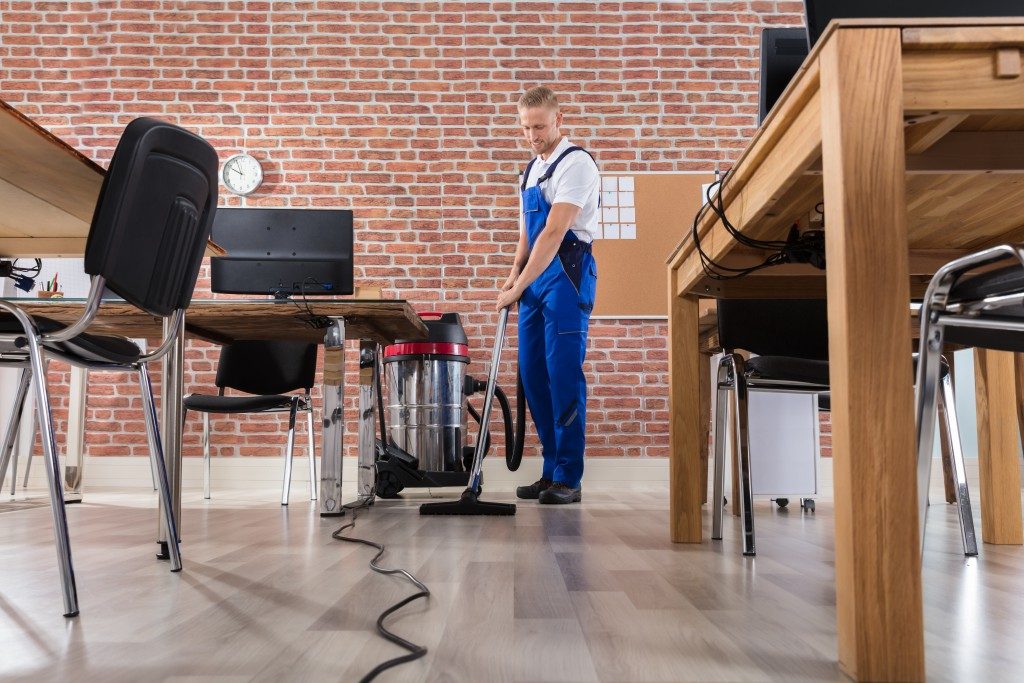 Male janitor cleaning office