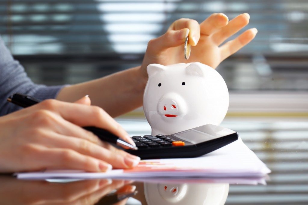 woman putting coin in piggybank