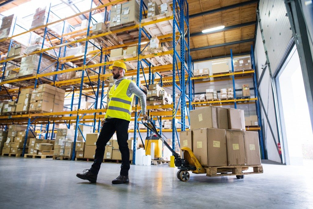 Man pulling pallet truck in warehouse