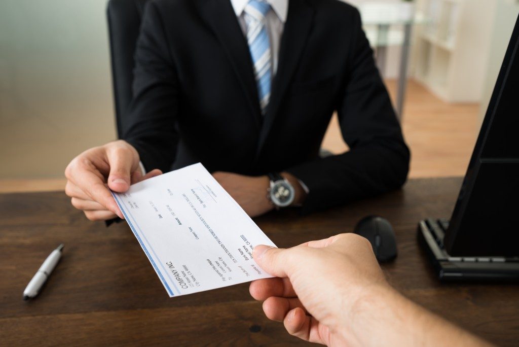 person handing check to employee