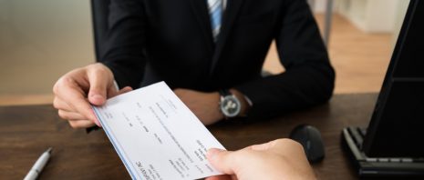 person handing check to employee