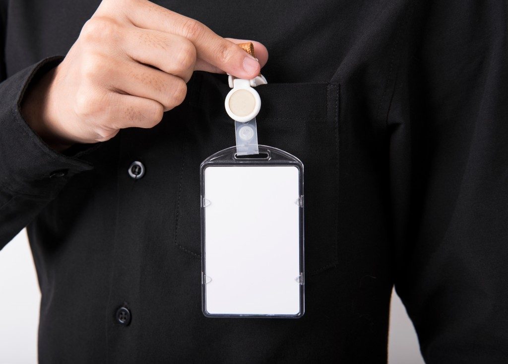 employee hand showing blank id card badge holder