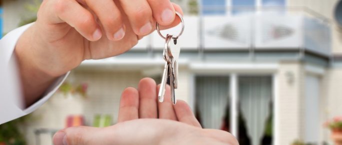 real estate agent handing keys to owner