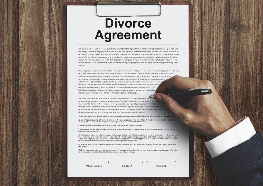 a man signing a divorce agreement