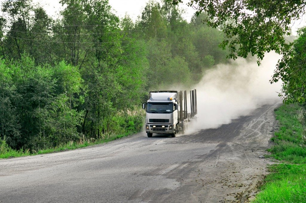 truck traveling fast down a dusty road